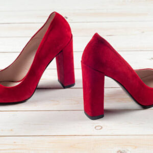 Red female shoes on high heels isolated on white wooden background